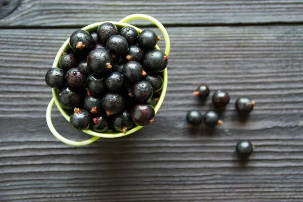 Färska söta svarta vinbär i skålen — Stockfoto