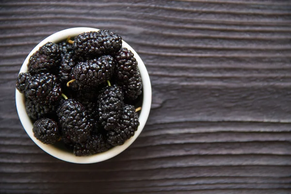 Färska mulberry i skål på trä bakgrund — Stockfoto