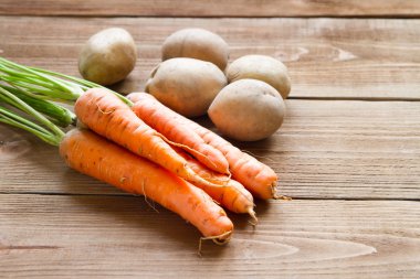 Taze havuç ve patates ahşap arka plan üzerinde