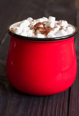 Kakao marshmallows ahşap bir masa üzerinde kırmızı bir fincan ile