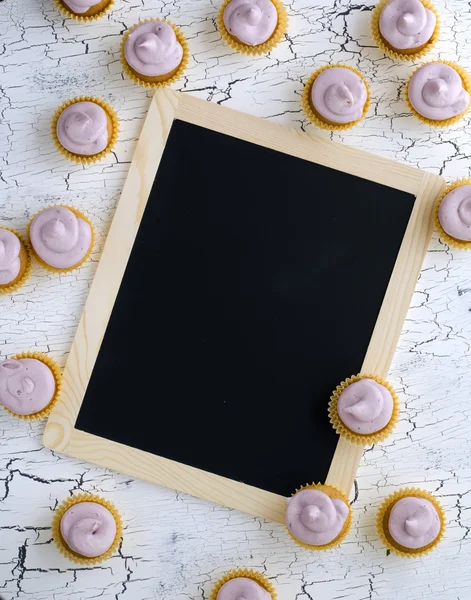 Schwarze Tafel mit und Mini-Cupcakes — Stockfoto