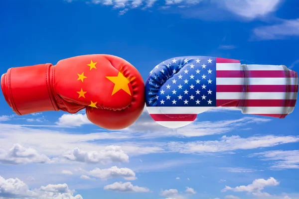 Flags of USA and China on blue cloudy sky background, us china trade war concept.