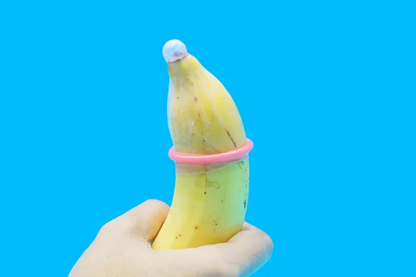 避孕套的蓝色背景上戴着一个香蕉 预防性传播疾病和避孕的安全概念 — 图库照片