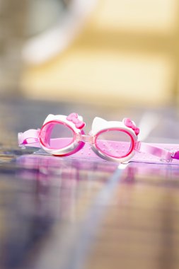 The swimming glasses are placed beside pool.