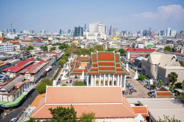 Bangkok 'un panoramik bir şehir manzarası Altın Dağ' ın tepesinden, parlak bir gökyüzünün altındaki tapınakları ve modern binaları gösteriyor..