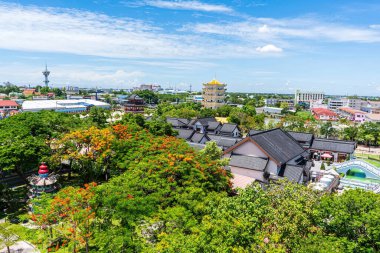 Suphan Buri kültürel köyünün ve güneşli gökyüzünün altındaki altın tapınağın geniş hava manzarası.