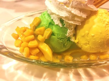 Üzerine tatlı mısır ve krem şantili sarı ve yeşil dondurma..