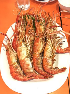 Beyaz tabakta hazırlanmış ızgara nehir karideslerinin üst görüntüsü..