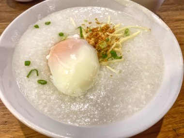 Bir kase sıcak pirinç lapası ya da üzerine yumurta, zencefil ve kızarmış sarımsak konmuş pirinç lapası..