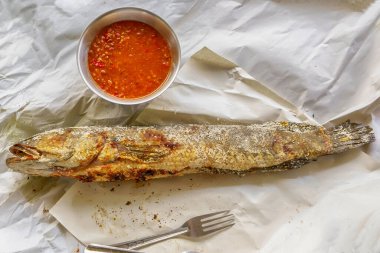 Geleneksel Tayland usulü ızgara yılan başı balığı. Baharatlı sos ile servis edilmiş tuzlu kabuklu..