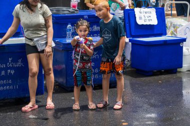 Silom, Bangkok, Tayland - APR 12, 2025 Songkran Festivali, Tayland Yeni Yılı kutlamalarına katılan insanların kısa eylemi. Sıçrama ve toz vardı. Songkran sırasında insanlar sırılsıklam oluyor..