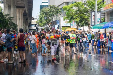 Silom, Bangkok, Tayland - APR 12, 2025 Songkran Festivali, Tayland Yeni Yılı kutlamalarına katılan insanların kısa eylemi. Sıçrama ve toz vardı. Songkran sırasında insanlar sırılsıklam oluyor..