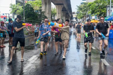 Silom, Bangkok, Tayland - APR 12, 2025 Songkran Festivali, Tayland Yeni Yılı kutlamalarına katılan insanların kısa eylemi. Sıçrama ve toz vardı. Songkran sırasında insanlar sırılsıklam oluyor..