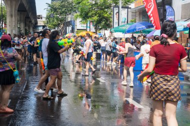 Silom, Bangkok, Tayland - APR 12, 2025 Songkran Festivali, Tayland Yeni Yılı kutlamalarına katılan insanların kısa eylemi. Sıçrama ve toz vardı. Songkran sırasında insanlar sırılsıklam oluyor..