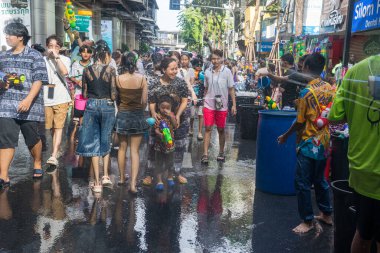 Silom, Bangkok, Tayland - APR 12, 2025 Songkran Festivali, Tayland Yeni Yılı kutlamalarına katılan insanların kısa eylemi. Sıçrama ve toz vardı. Songkran sırasında insanlar sırılsıklam oluyor..