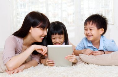 Tablet bilgisayar kullanan Asyalı bir aile
