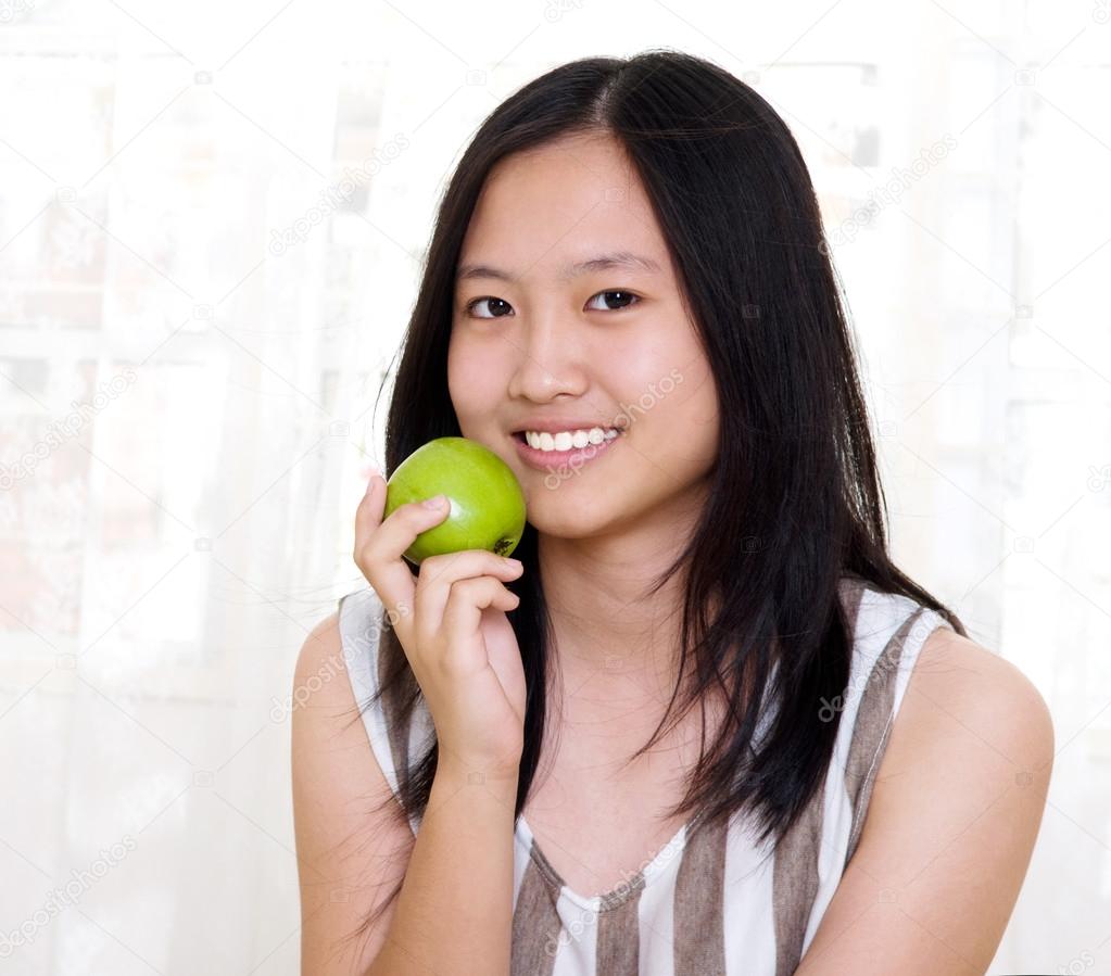 Asian teenager eatng apple