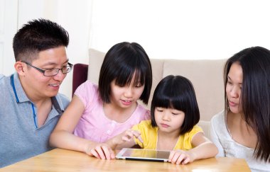 Tablet bilgisayar kullanan Asyalı bir aile