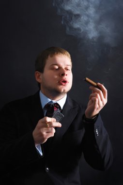 Adam bir puro ile lots-in duman duman. Koyu arka plan