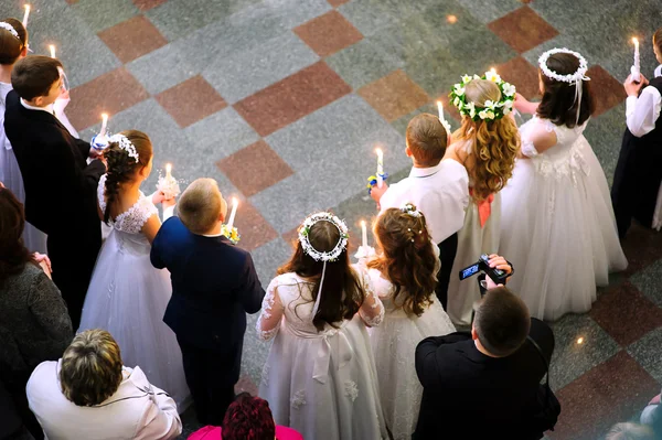 Primeira comunhão santa na igreja, muitas crianças — Fotografia de Stock