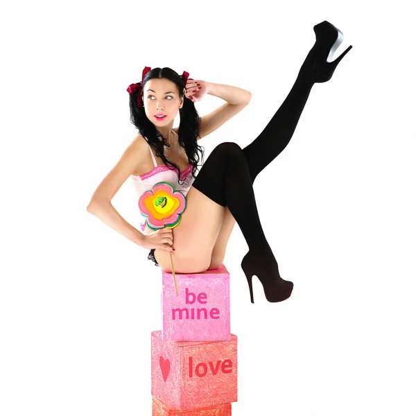 Sexy donna sorridente in bikini con grande caramella lecca-lecca seduta su scatole regalo — Foto Stock