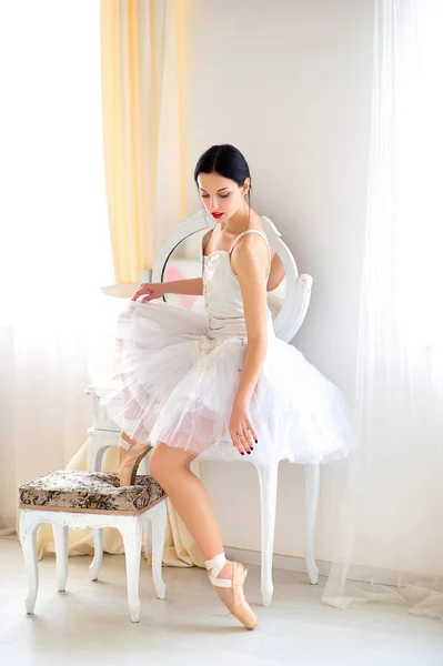 Beleza morena bailarina no interior, vestindo saia de balé e espartilho Fotografia De Stock