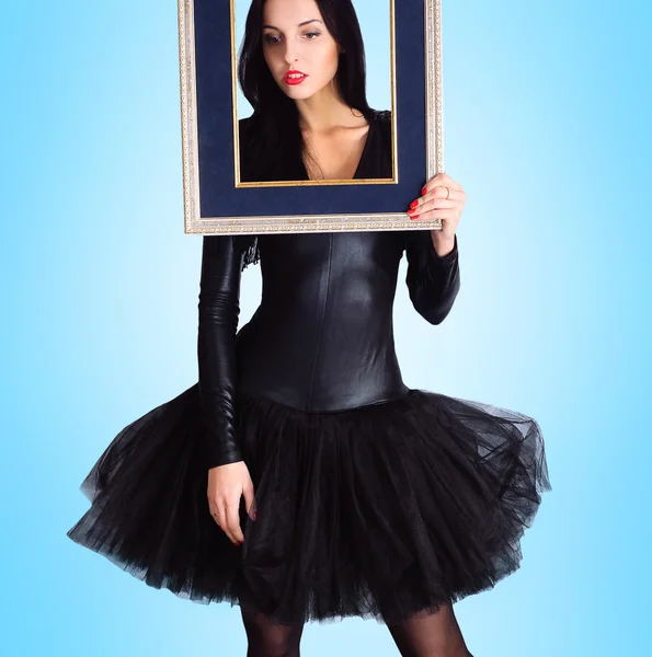 Mulher vestindo em vestido preto segurando quadro de imagem — Fotografia de Stock