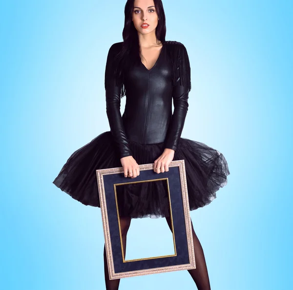 Mulher vestindo em vestido preto segurando quadro de imagem — Fotografia de Stock