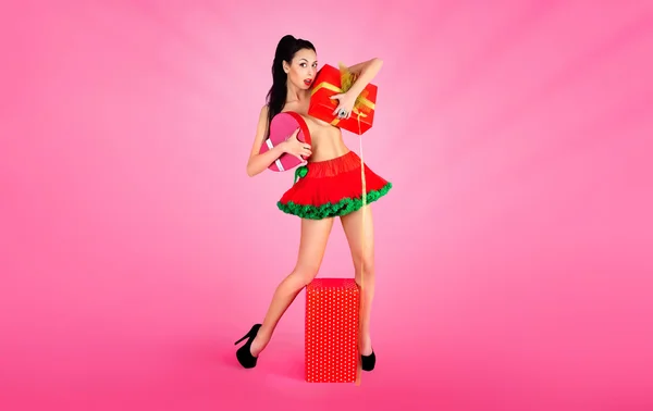 Chica desnuda alegre en falda roja, divertirse emocionalmente disfrutando de la celebración de cajas de regalo en el fondo. San Valentín —  Fotos de Stock