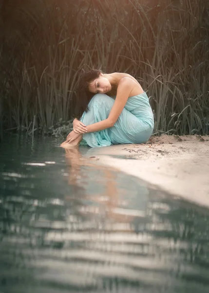 Menina encantadora e romântica dormindo e sonhos perto do córrego da água. Ao ar livre Imagem De Stock