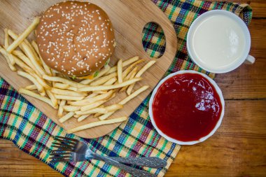 Fast food büyük hamburger ve patates kızartması ahşap arka plan ayarla