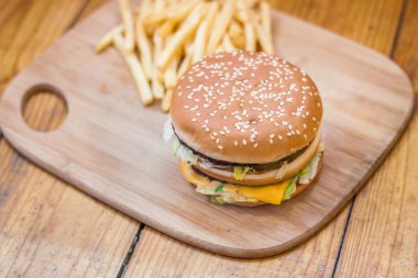 Fast food büyük hamburger ve patates kızartması ahşap arka plan ayarla