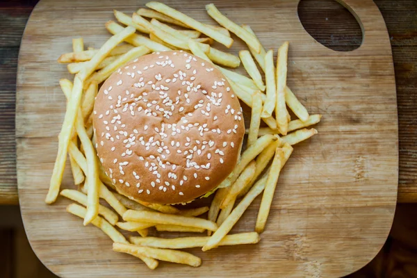 Fast food mis gros hamburger et frites sur fond de bois — Photo