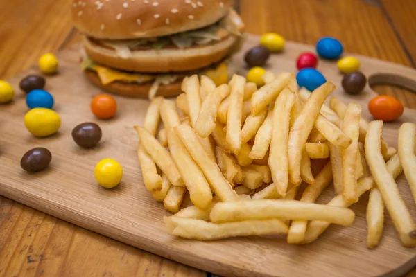 Fast food mis gros hamburger et frites sur fond de bois — Photo