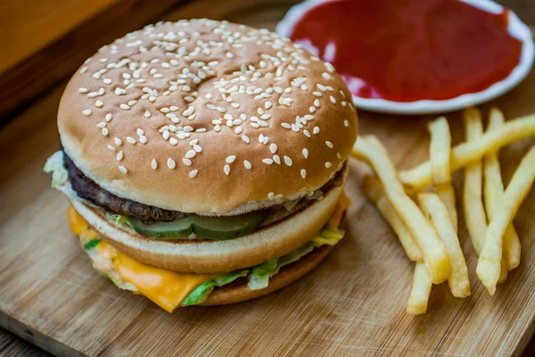 Fast food büyük hamburger ve patates kızartması ahşap arka plan ayarla — Stok fotoğraf