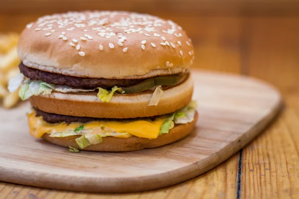Fast food büyük hamburger ve patates kızartması ahşap arka plan ayarla