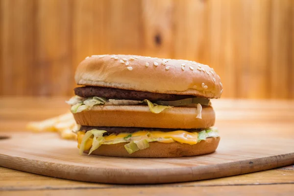 Fast food büyük hamburger ve patates kızartması ahşap arka plan ayarla — Stok fotoğraf