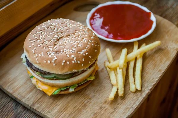 Fast food büyük hamburger ve patates kızartması ahşap arka plan ayarla — Stok fotoğraf