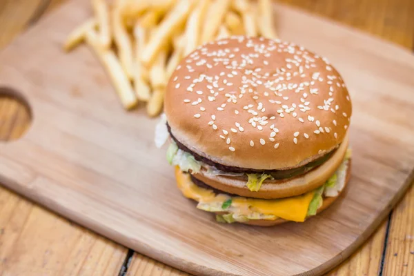 Fast food mis gros hamburger et frites sur fond de bois — Photo