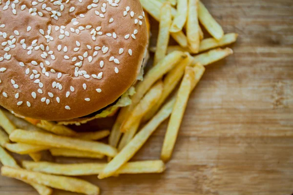 Fast food büyük hamburger ve patates kızartması ahşap arka plan ayarla — Stok fotoğraf