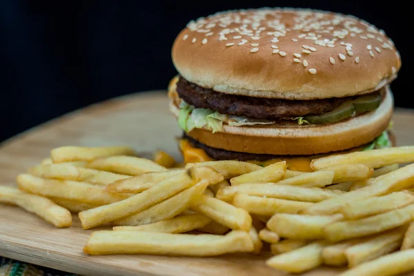 Fast food büyük hamburger ve patates kızartması ahşap arka plan ayarla — Stok fotoğraf