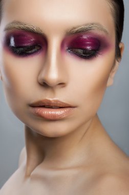 Pembe gözleri ve dudakları gri bir arka plan üzerinde güzel yüz