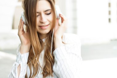 güzel kız sokakta kulaklık ile müzik dinlemek 