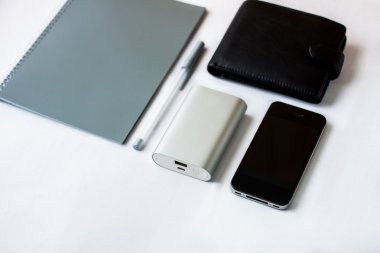 Beyaz tablo nesnelerde (telefon, cüzdan, defter, kalem, taşınabilir şarj)