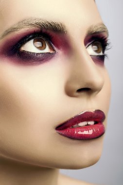 Pembe gözleri ve dudakları gri bir arka plan üzerinde güzel yüz