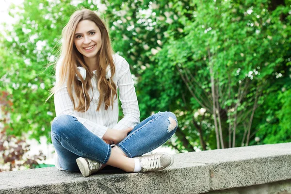 Bella ragazza seduta all'aperto nel parco e sorridente — Foto Stock