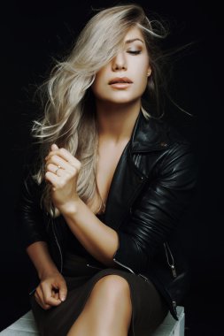 çok güzel bir kız bir deri stüdyoda bir sandalyede oturan