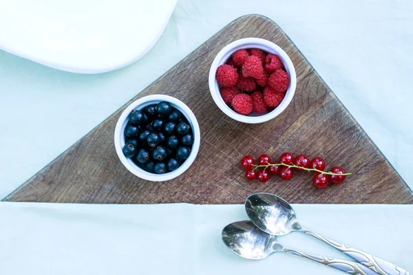 Fruta en la mesa. Grosellas negras, frambuesas en bandejas. Peras — Foto de Stock