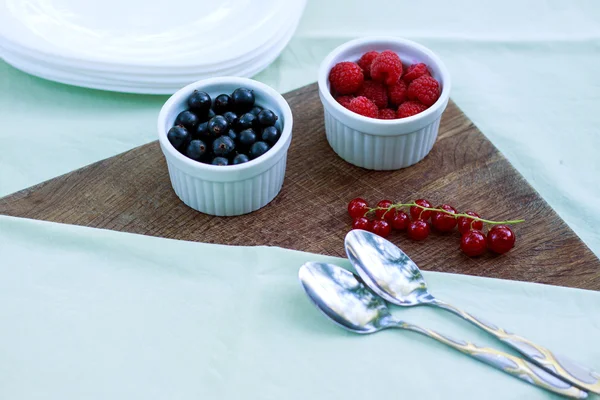 Fruta en la mesa. Grosellas negras, frambuesas en bandejas. Peras — Foto de Stock
