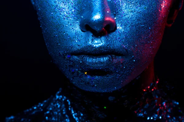 Κοντινό πορτρέτο ενός κοριτσιού με γκλίτερ στο πρόσωπό της. στο πρόσωπο μπλε και κόκκινο φως. μεγάλη φωτογραφία των γυναικείων χειλιών. — Φωτογραφία Αρχείου